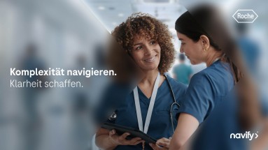 Zwei Krankenschwestern mit einem Tablet sind auf dem Bild zu sehen.